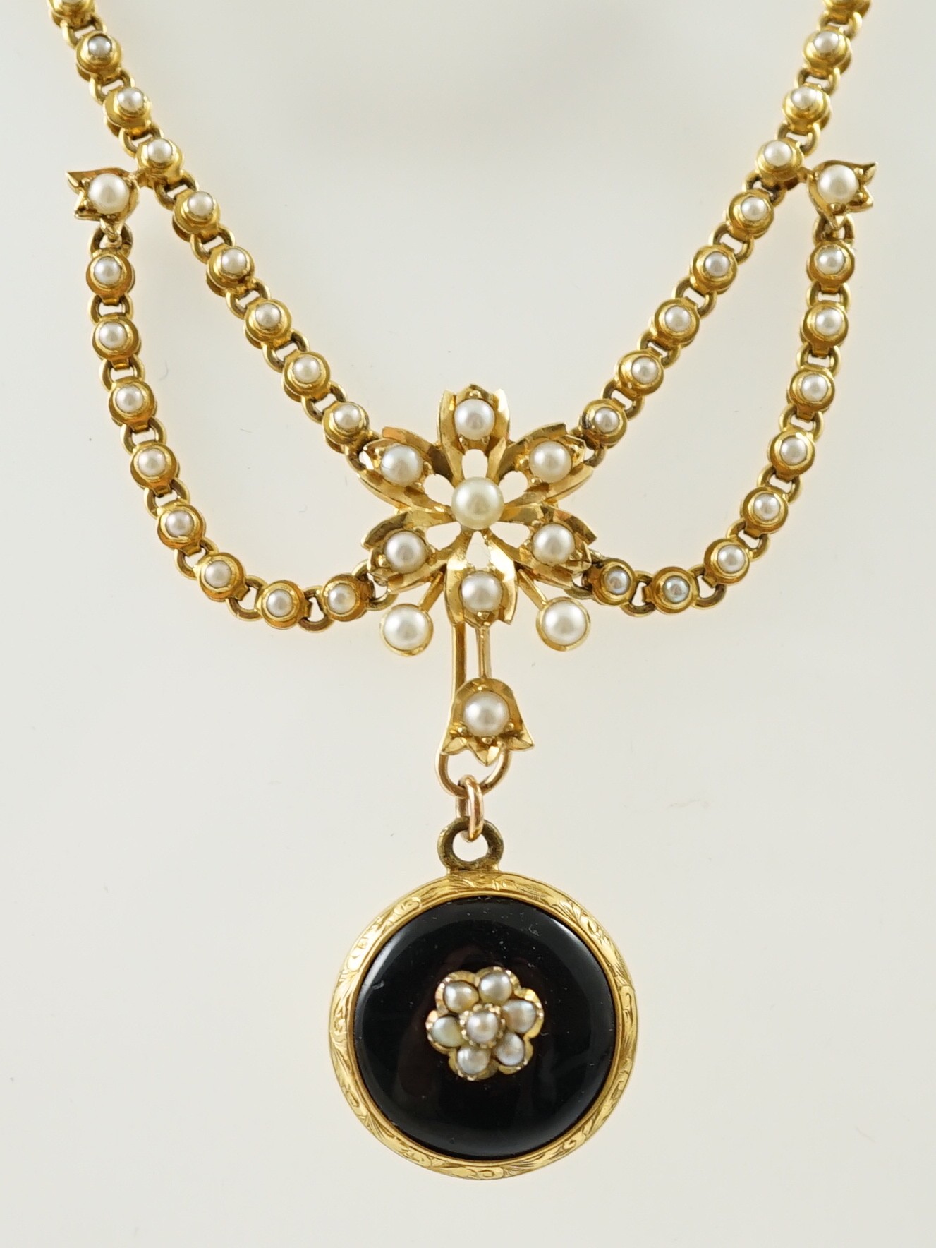 A Victorian gold, black enamel and seed pearl set mourning pendant necklace